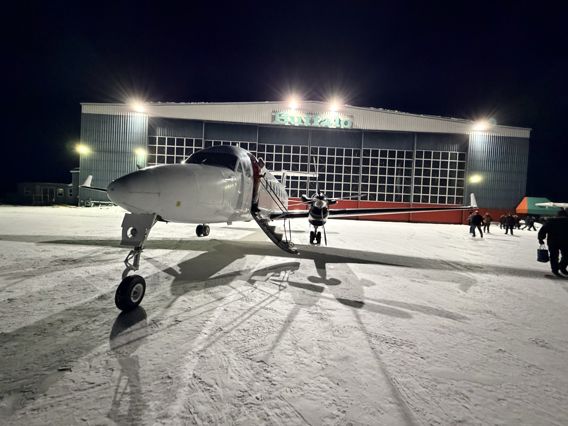 The 1900D loading at night in front of the lit Buffalo hangar