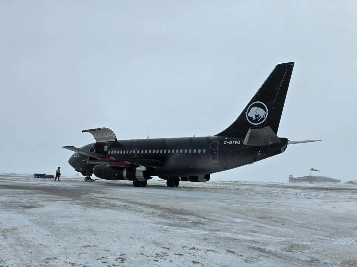 C-GTVO with the cargo door open at a remote gravel strip, windsock beyond