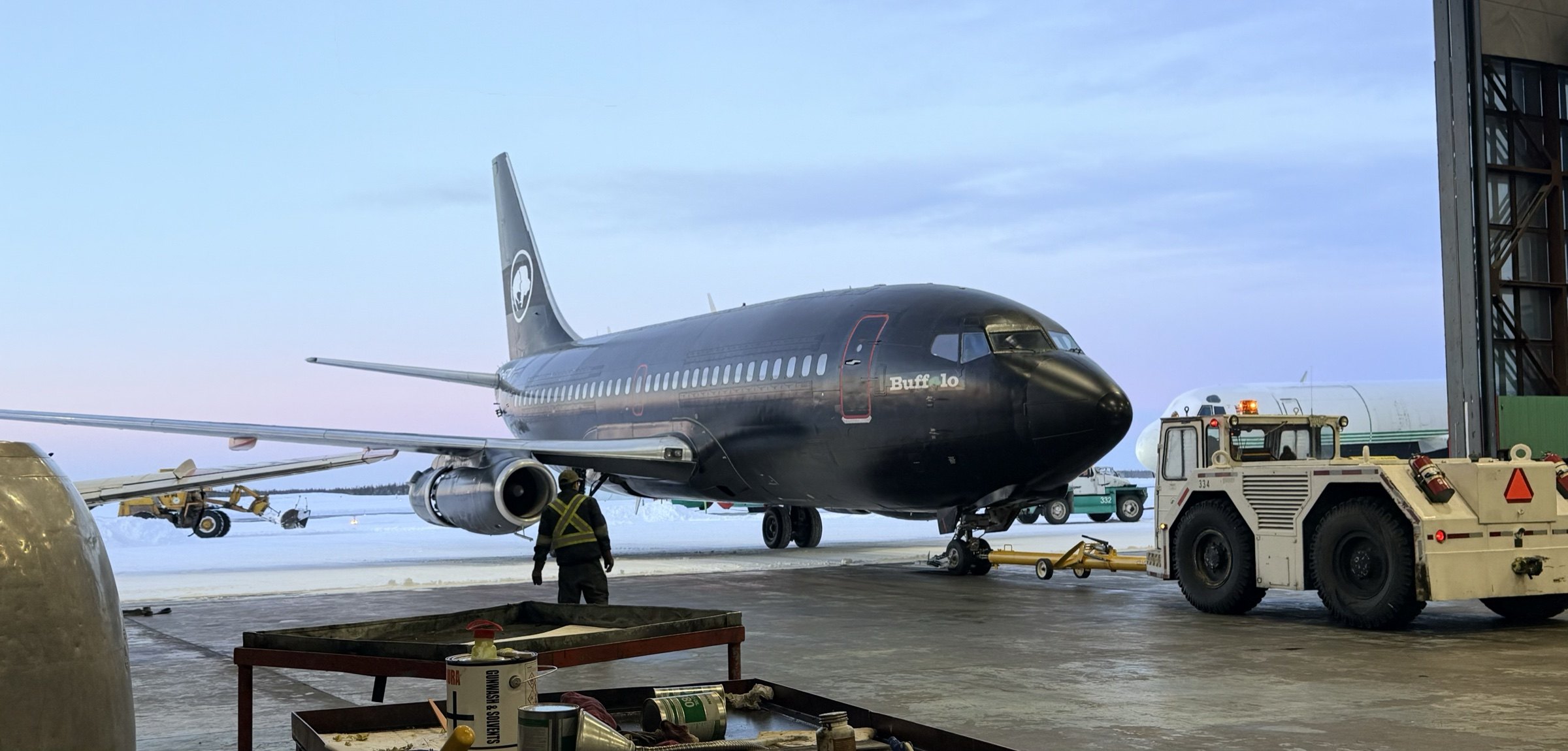 C-GTVO being towed into the Yellowknife hangar in winter twilight