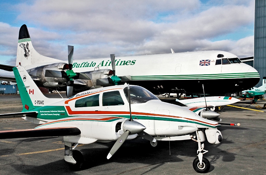 A Cessna 310 in Buffalo colours with an Electra behind it