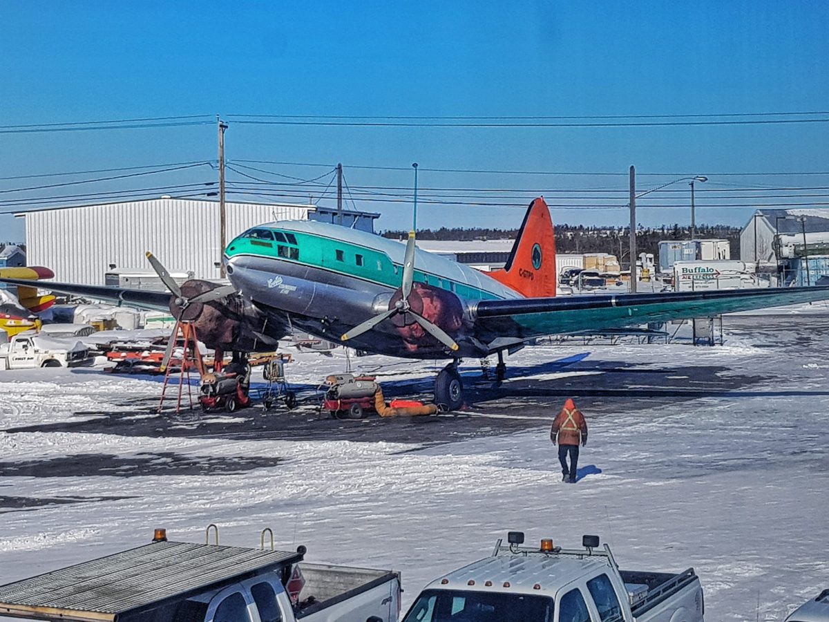 A C-54 with an orange tanker tail on the Yellowknife ramp — the type that started Buffalo’s fire story