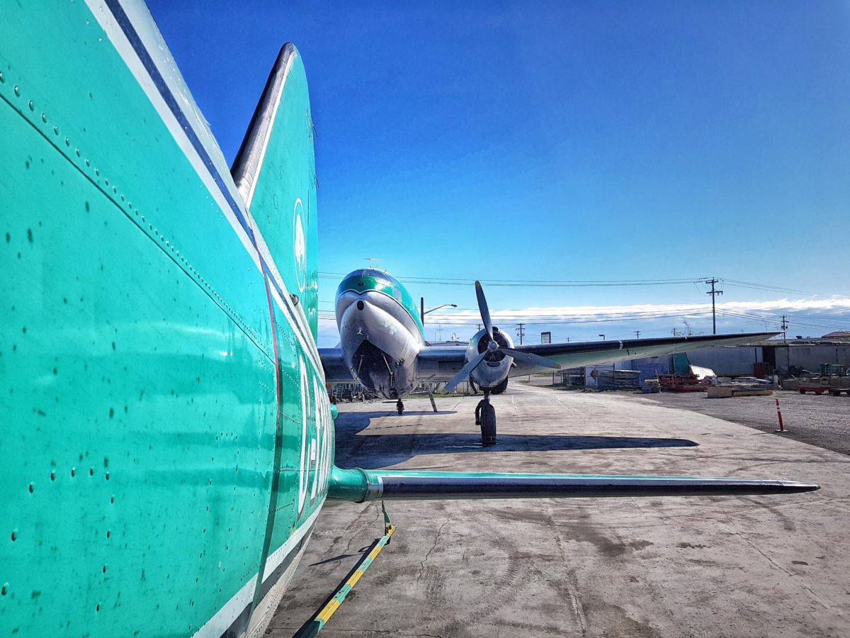 Along a Commando’s tail fin to a second C-46 head-on outside the hangar