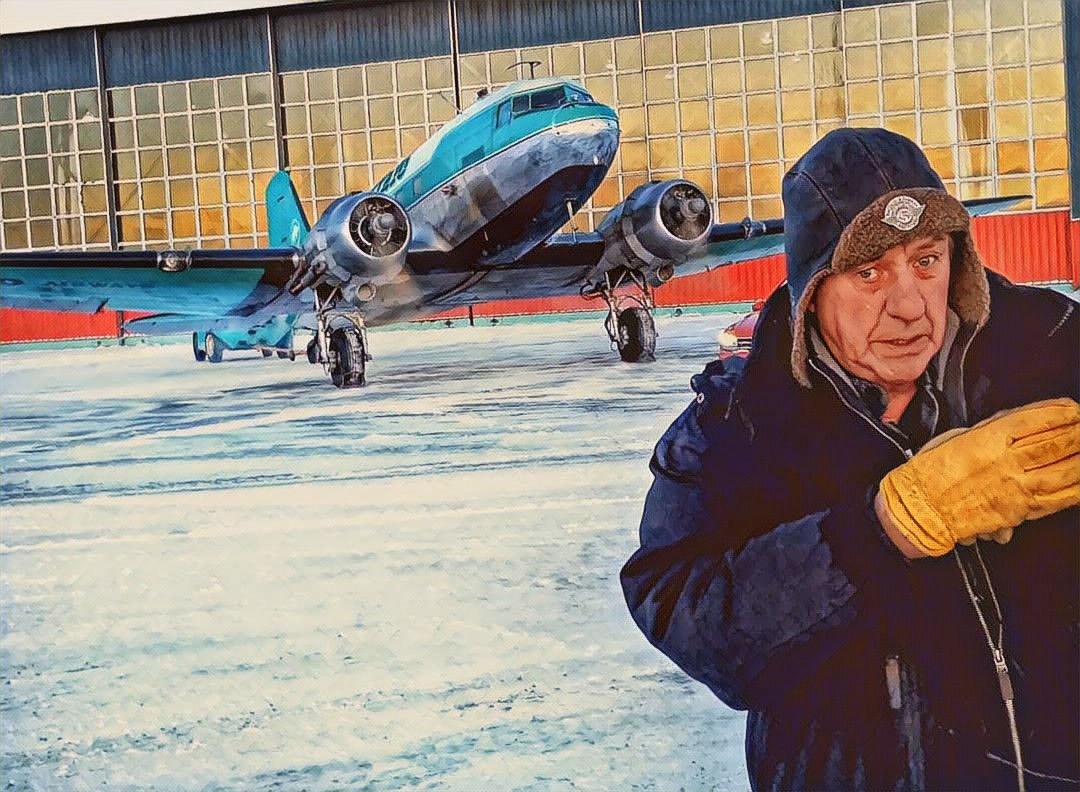 Buffalo Joe McBryan in winter gear in front of a DC-3 outside the Yellowknife hangar