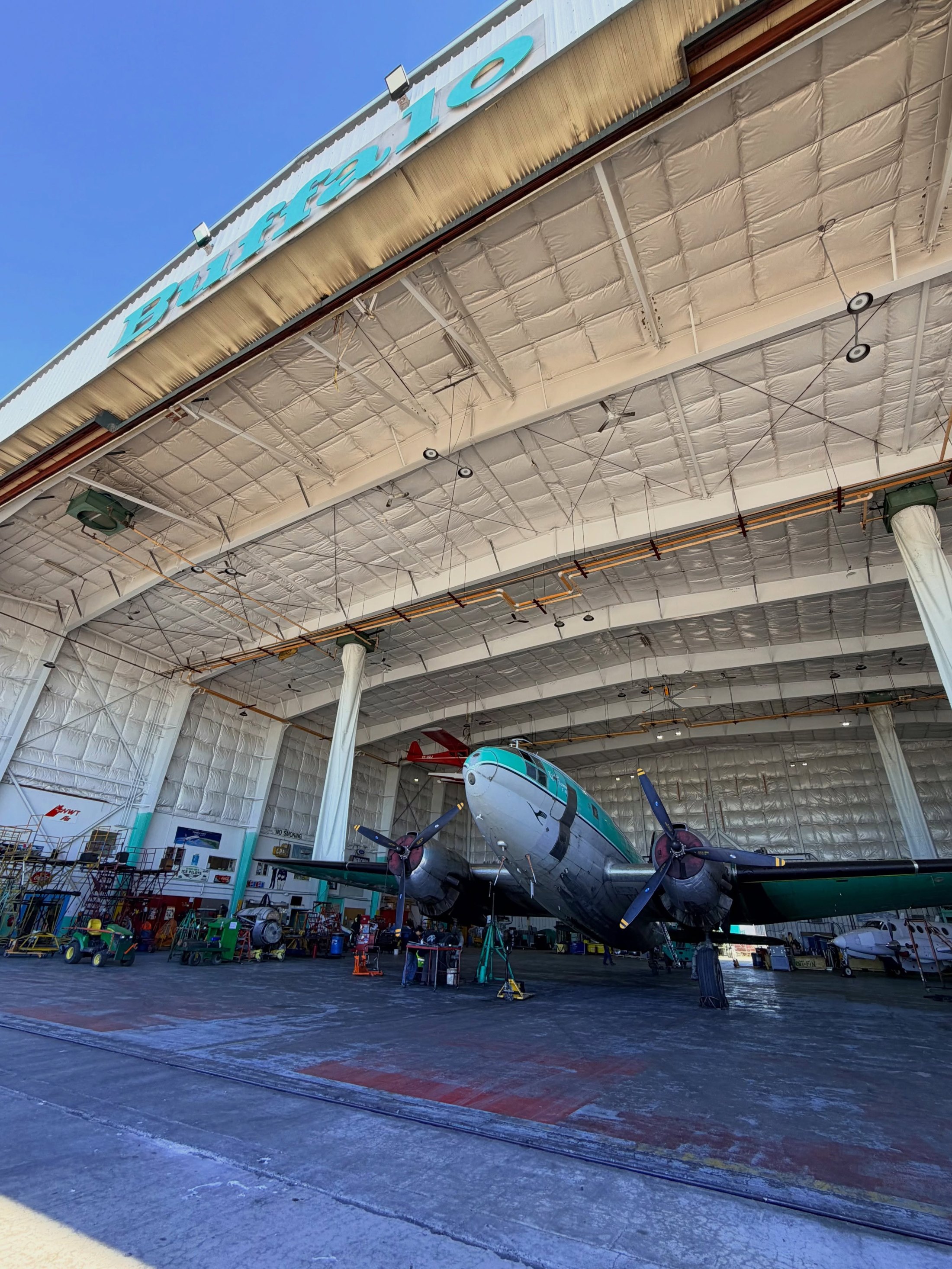 Looking up into the Buffalo hangar as a Commando sits on jacks for brake work