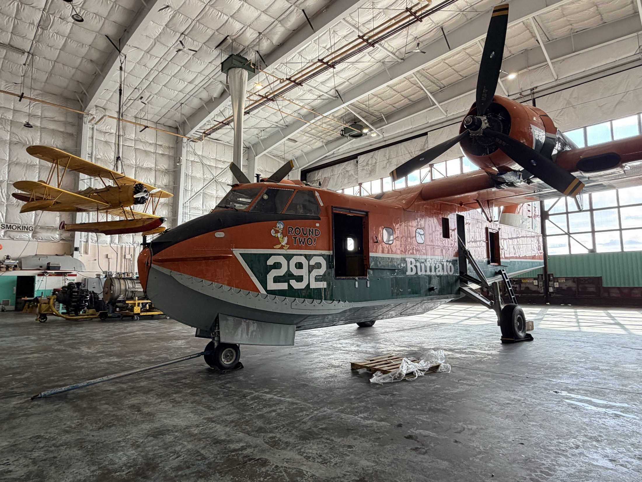 Tanker 292 — Round Two! — in the Buffalo hangar beneath the yellow N3N