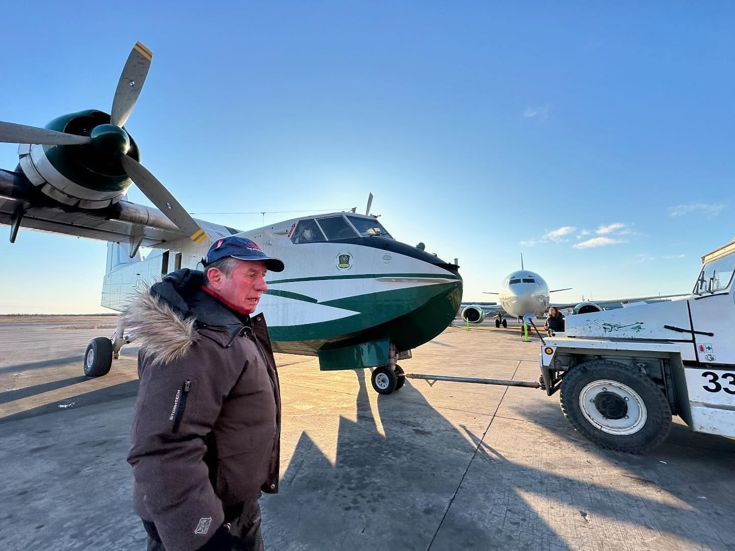Buffalo Joe walks past the newest CL-215 as it is towed in, a Buffalo 737 beyond