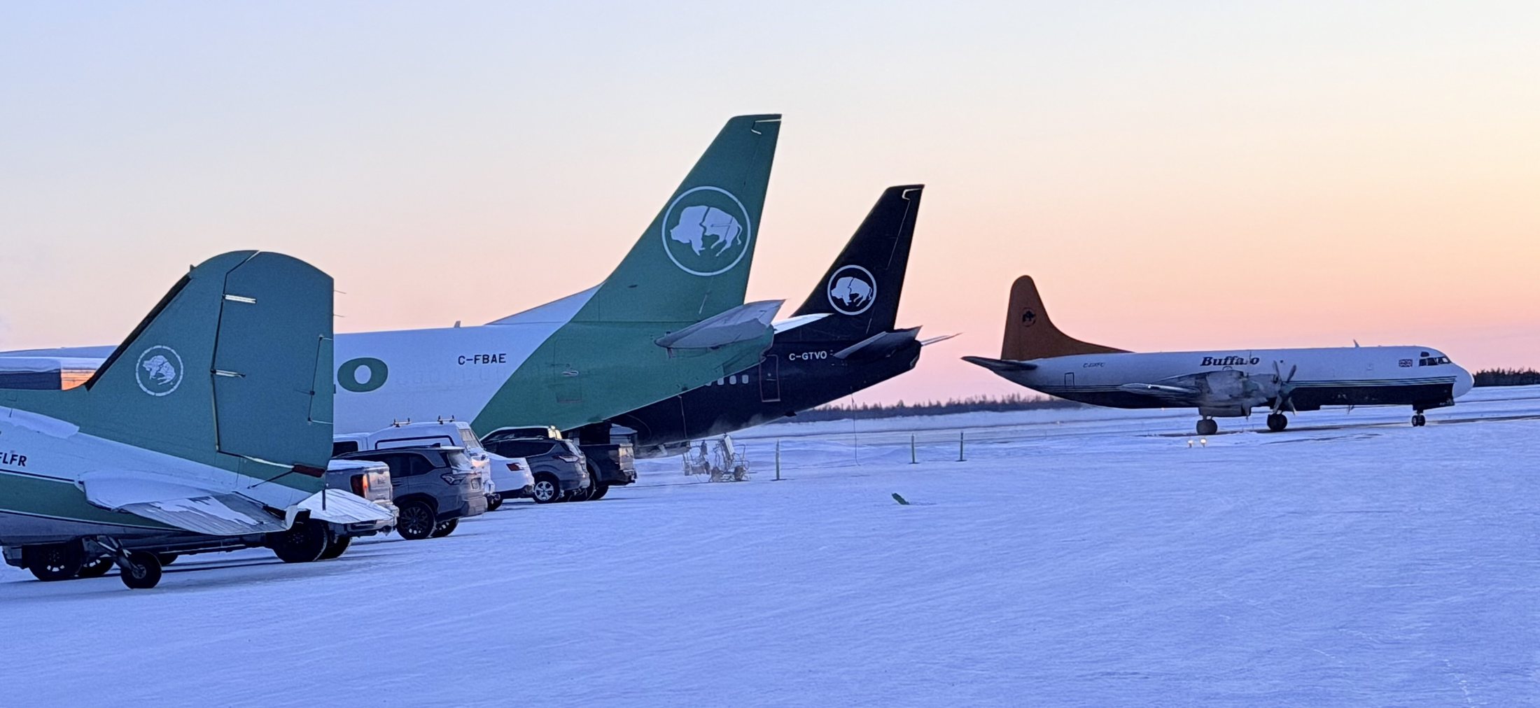 Both 737s tail to tail on the winter ramp at sunset, with a DC-3 and an Electra alongside