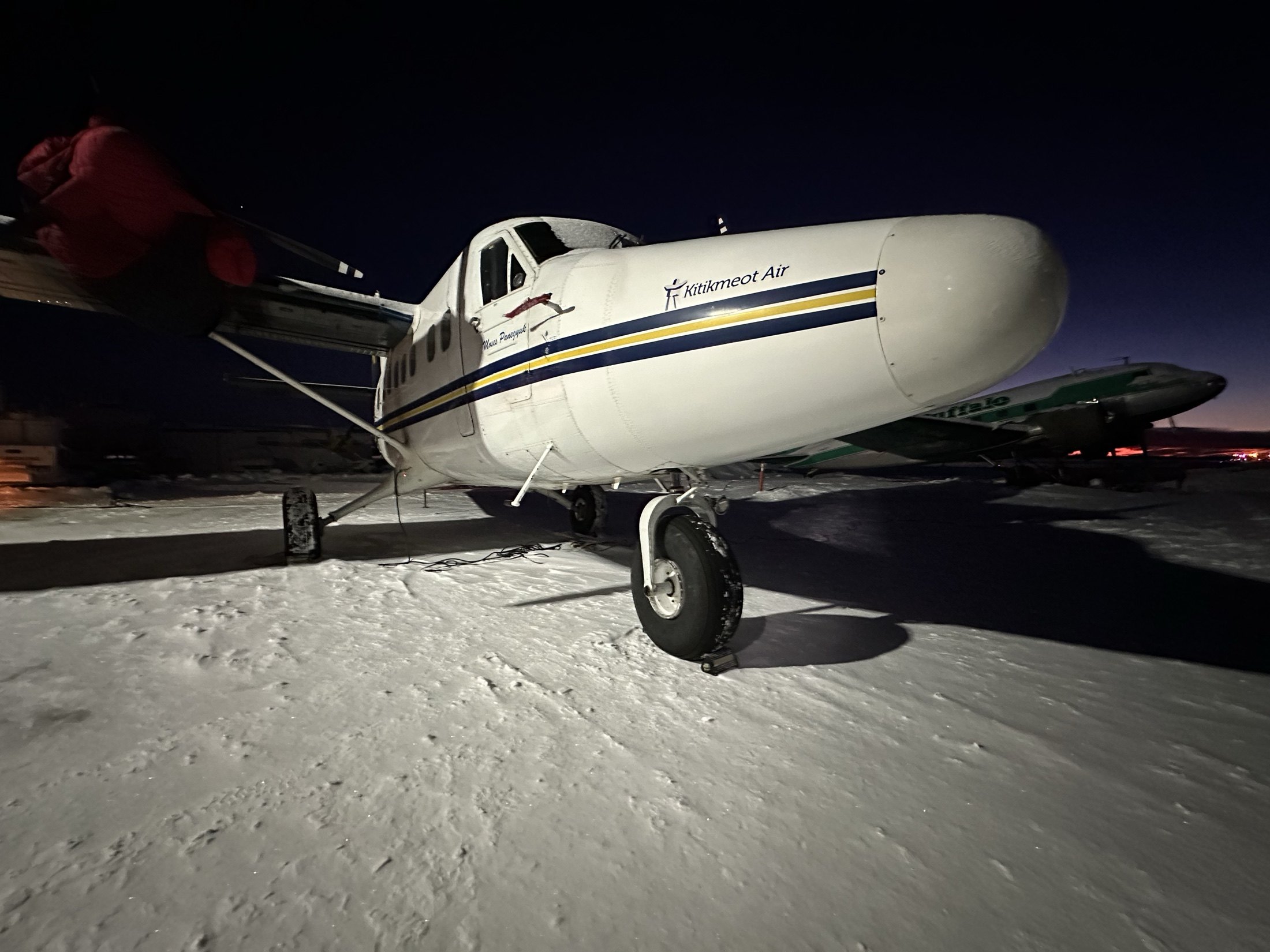 Night on the ramp — C-GFYN still wearing its Kitikmeot Air heritage titles, a Buffalo C-46 behind